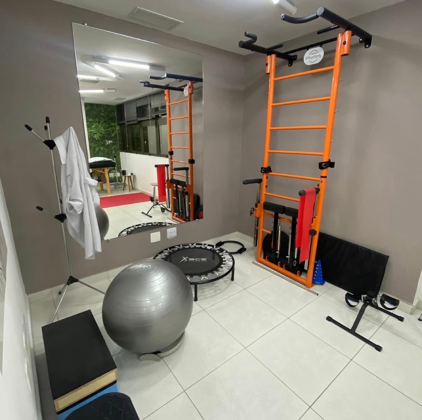 Sala de pilates da Clínica Mandira, com espaldar, bola suíça e mini trampolim